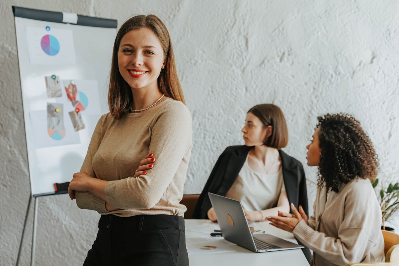 Confident woman smiling in a modern office setting with colleagues at work.